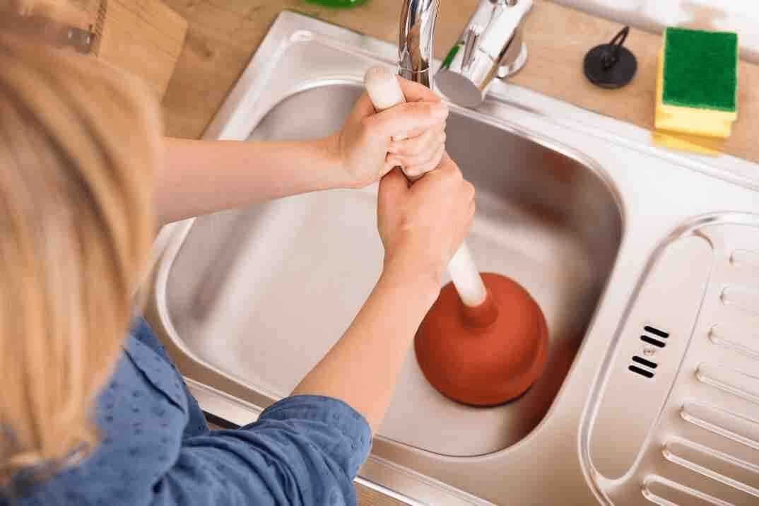 Expert plumber fixing bathroom drain choke